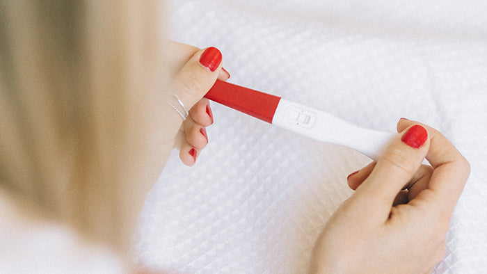 Image of woman holding pregnancy test