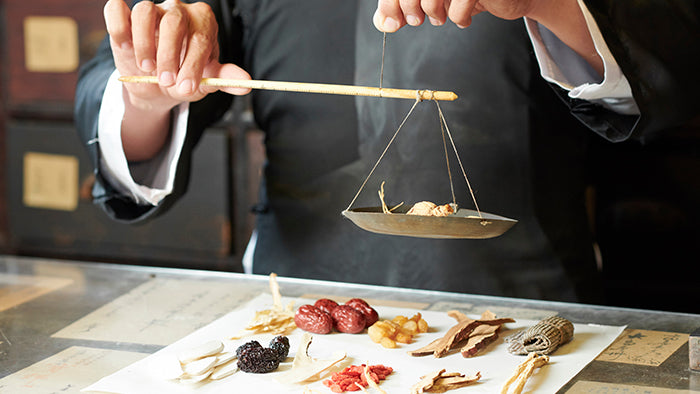 Chinese medicine doctor weighing herbs